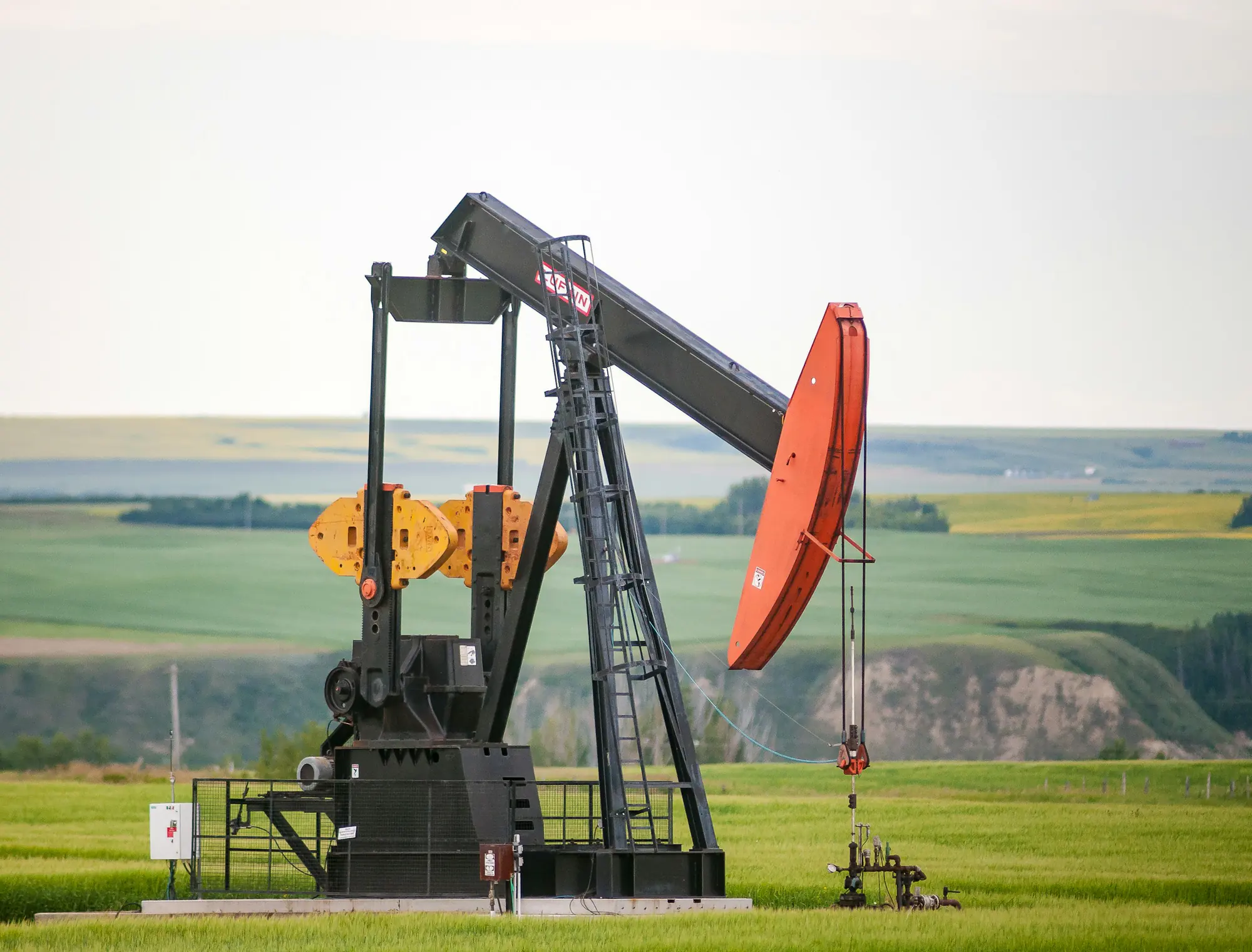 Oil pump jack in a green field, from the Peak ETL oil and gas data platform