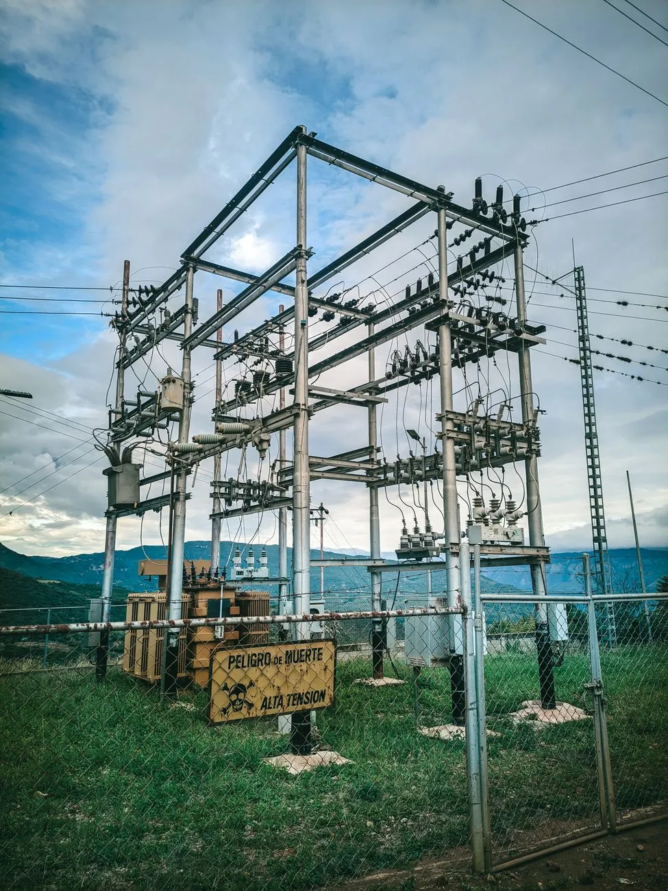 Electrical substation steel frame and insulators under a cloudy sky